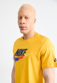 Nike Sportswear TEE - T-shirt imprimé - university gold